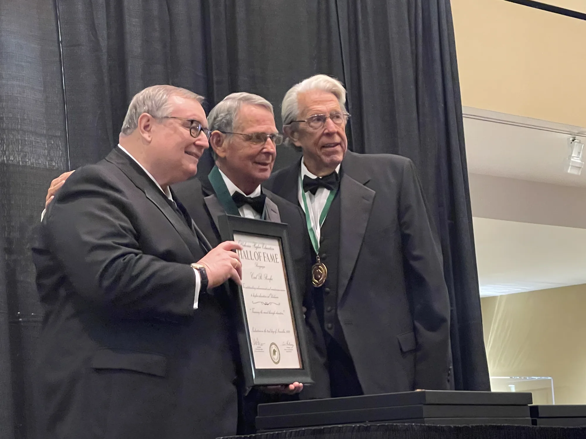 Carl Renfro on stage receiving his Oklahoma Higher Education Hall of Fame certificate